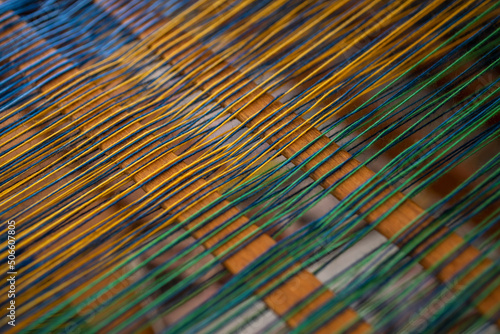 Close up green and yellow thread on loom
 photo