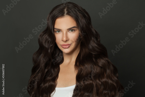 Brunette woman with long dark shiny curly hair portrait