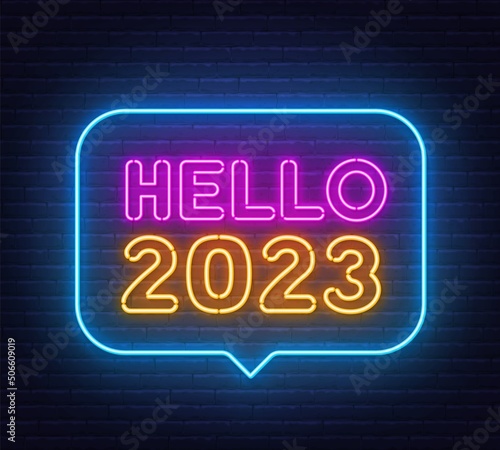 Hello 2023 neon sign in the speech bubble on brick wall background.