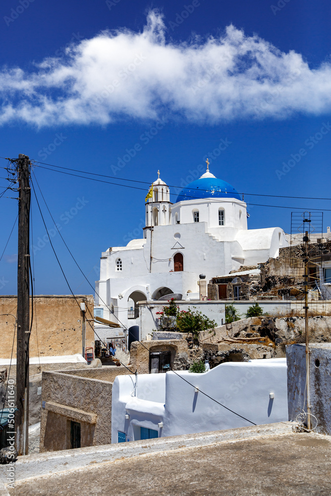 Fototapeta premium White church with a blue dome on Santorini island in Greece. Hot summer sun day.