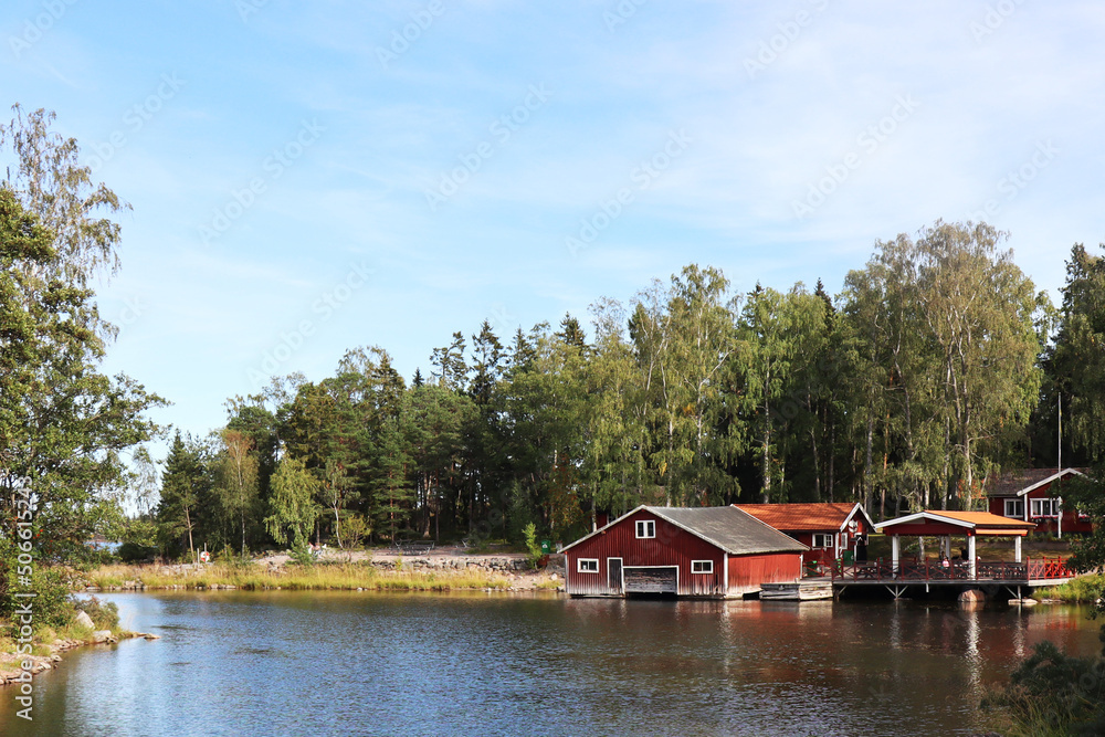 landscape view of a typical red swedish house with a lake landscape view of a typical red swedish house with a lake