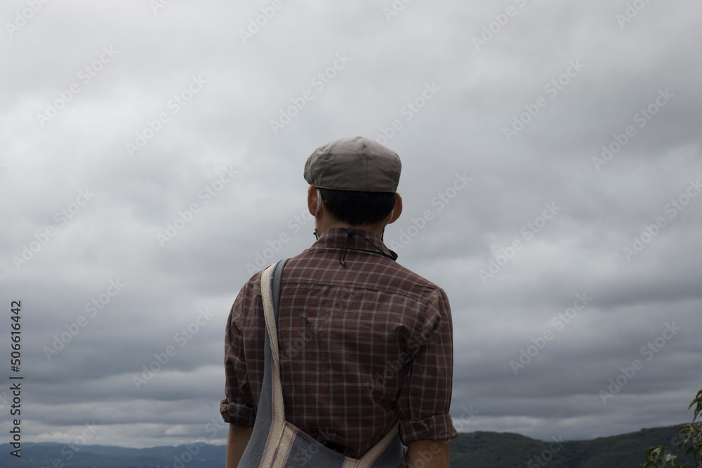 person one standing back facing the sky and mountains. person one standing back facing the sky and mountains.
