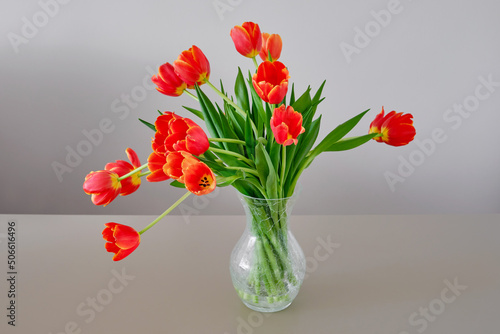 Beautiful spring bouquet of orange tulips flowers. Spring holiday concept. Fresh beautiful fully open bunch of colorful parrot style tulips in the vase on the table. Selective focus