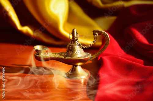 Golden oriental lamp of Aladdin with smoke.