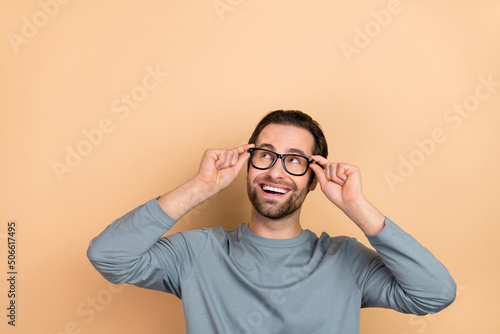 Photo of young cheerful guy eyewear look empty space wonder guess ophthalmologist isolated over beige color background