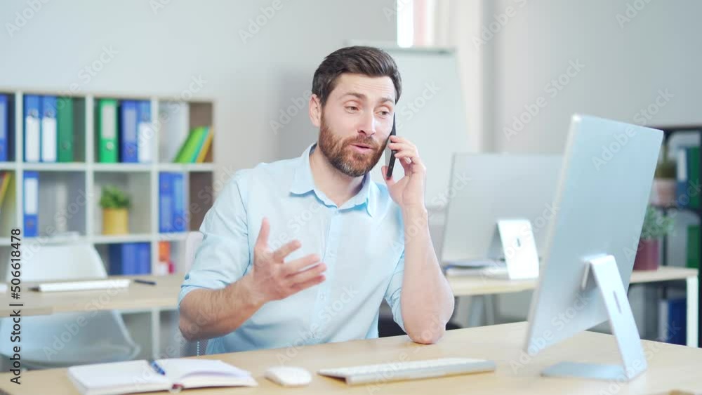 Happy cheerful office worker, employee entrepreneur happily talking on a mobile phone. Sitting at a computer desk in workplace. communication and conversation indoors. Laugh at the good news. Smile Happy cheerful office worker, employee entrepreneur happily talking on a mobile phone. Sitting at a computer desk in workplace. communication and conversation indoors. Laugh at the good news. Smile