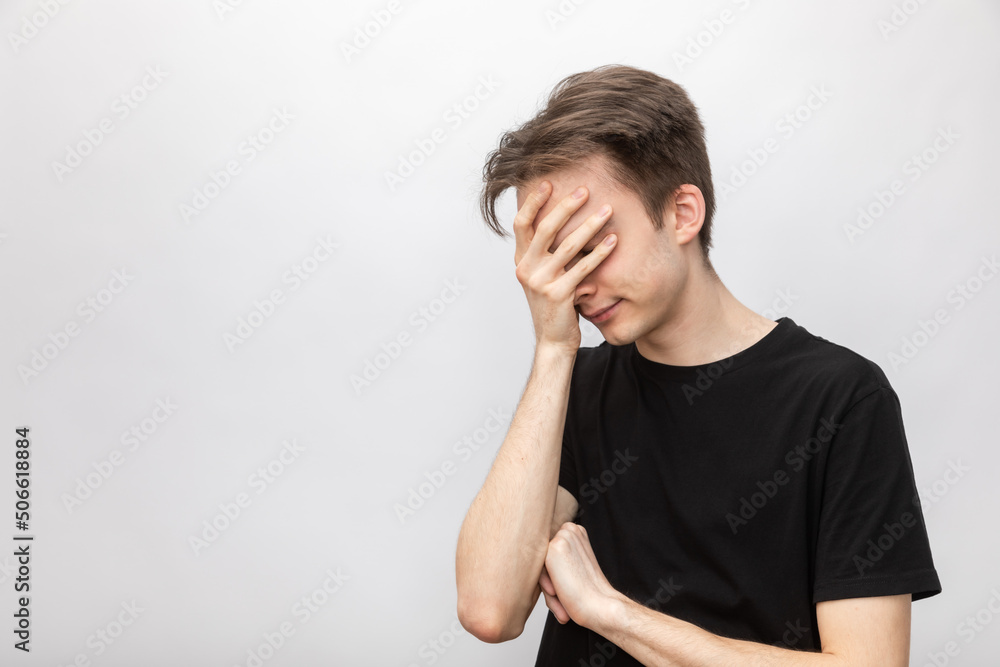 Young man doing facepalm studio shot on gray background Young man doing facepalm studio shot on gray background