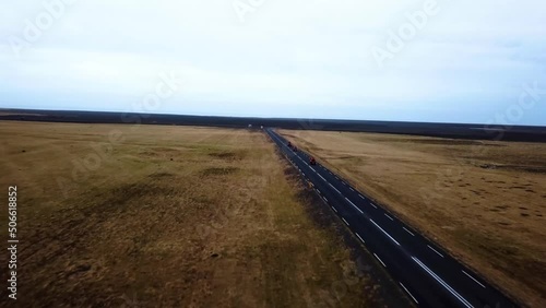 Aerial view of red quad bikes speeding on a empty straight road through Iceland highlands photo