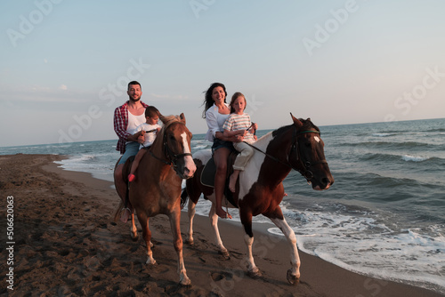 Wallpaper Mural The family spends time with their children while riding horses together on a sandy beach. Selective focus  Torontodigital.ca