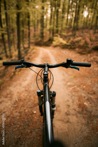 Close up of a suspension air fork on a mountain bike. Riding a bicycle in the forest. Concept of having fun while riding outdoors on a cross country bike. Hydraulic suspension absorbs offroad paths