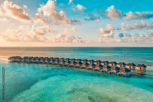 Maldives paradise sunset. Tropical aerial landscape, seascape with long jetty, water villas with amazing sea and lagoon beach, tropical nature. Exotic tourism destination banner, summer vacation