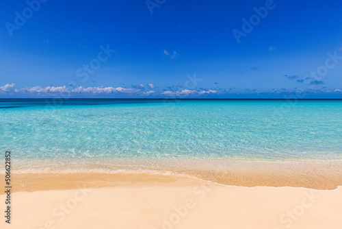Closeup of sand on beach and blue summer sky. Panoramic beach landscape. Empty tropical beach and seascape. Sunny blue sky, soft sand, calmness, tranquil relaxing sunlight, summer mood. Waves shore © icemanphotos