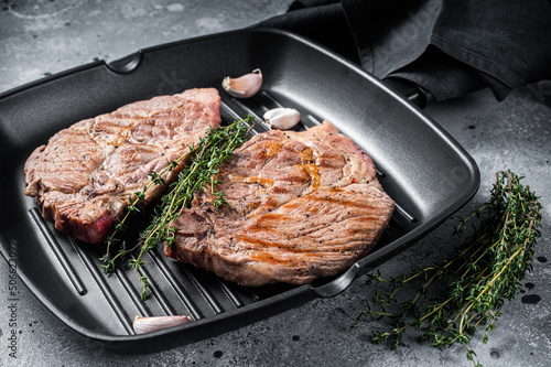 Grilled Pork Tender steaks from fillet meat on grill pan. Gray background. Top view
