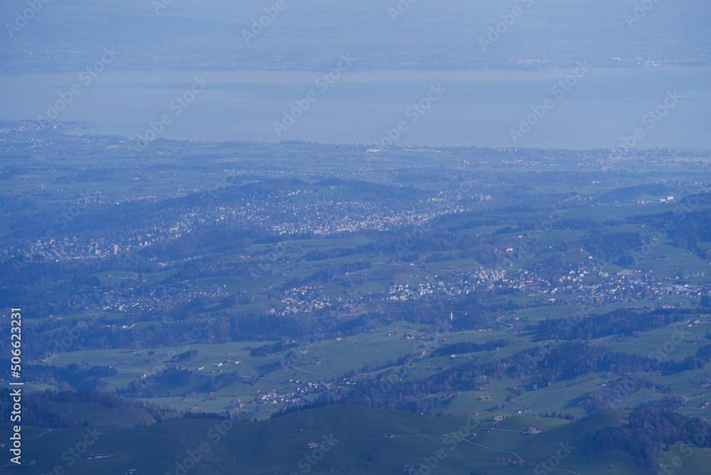 Aerial view with Mountains and midland and lake Bodensee in the background seen from Säntis peak at Alpstein Mountains on a sunny spring day. Photo taken April 19th, 2022, Säntis, Switzerland.