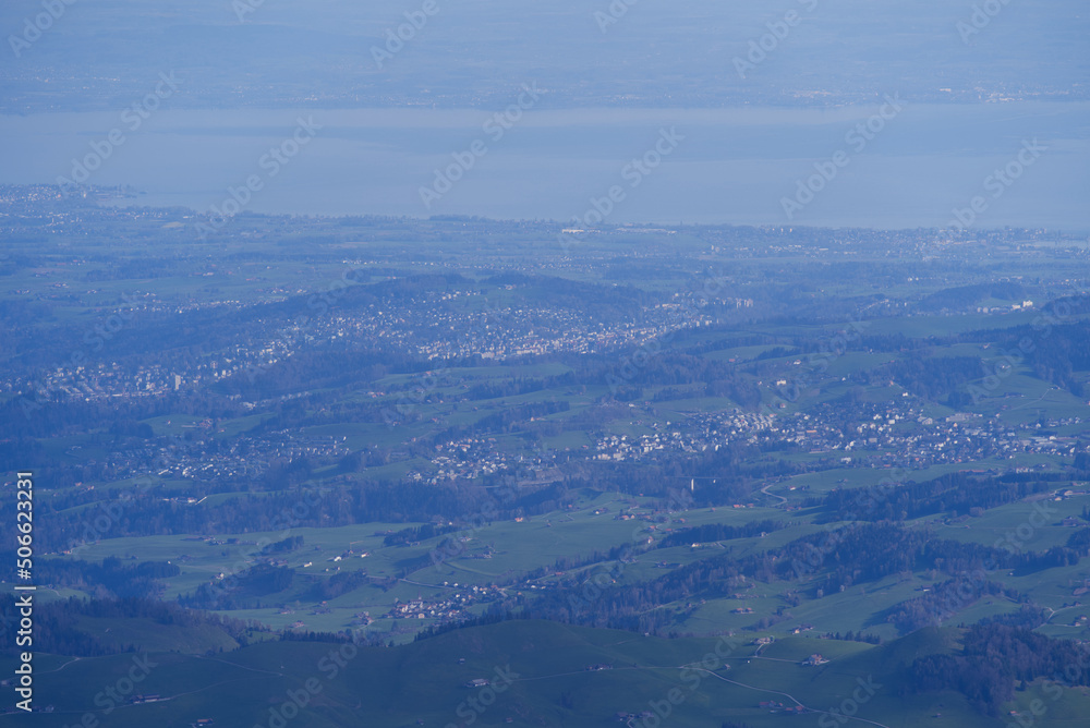 Fototapeta premium Aerial view with Mountains and midland and lake Bodensee in the background seen from Säntis peak at Alpstein Mountains on a sunny spring day. Photo taken April 19th, 2022, Säntis, Switzerland.