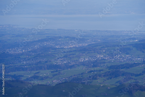 Aerial view with Mountains and midland and lake Bodensee in the background seen from Säntis peak at Alpstein Mountains on a sunny spring day. Photo taken April 19th, 2022, Säntis, Switzerland. © Michael Derrer Fuchs