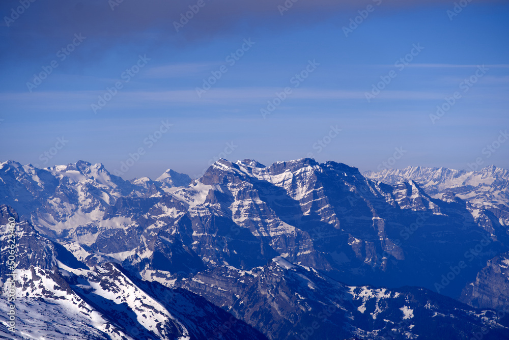 Aerial view over the Swiss Alps with Churfirsten and Toggenburg Valley seen from Säntis peak at Alpstein Mountains on a sunny spring day. Photo taken April 19th, 2022, Säntis, Switzerland.