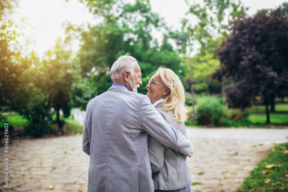 Senior active caucasian couple hugging looks happy in the park in the afternoon Senior active caucasian couple hugging looks happy in the park in the afternoon
