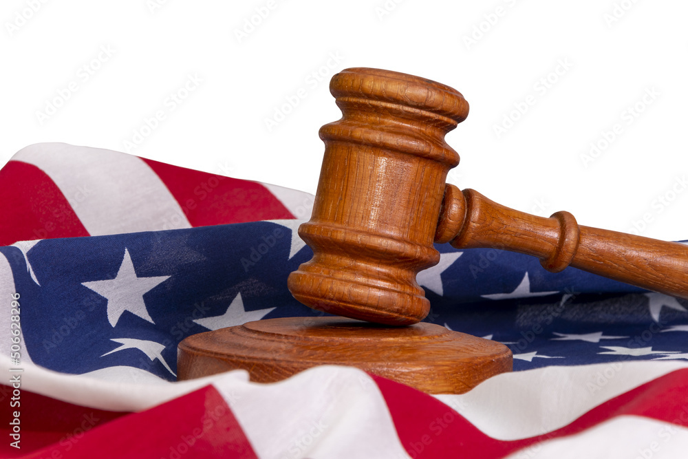Wooden judge's gavel on the background of the Wooden judge's gavel on the background of the American flag, a place for text, copy space. Concept: claim and compensation for damages, court session.