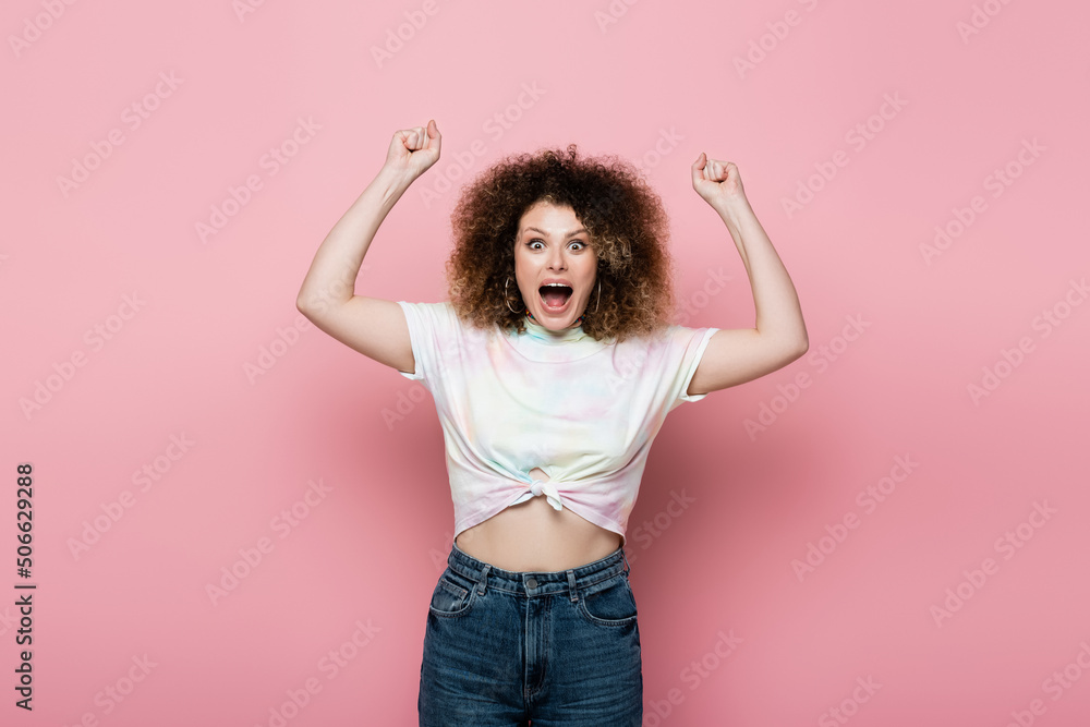 Excited woman in jeans and t-shirt showing yes gesture showing on pink background. Excited woman in jeans and t-shirt showing yes gesture showing on pink background.