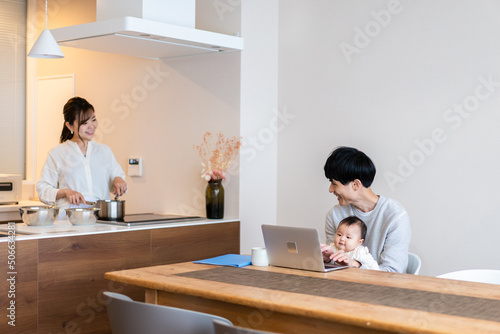赤ちゃんと一緒にパソコンを使うパパ © maroke