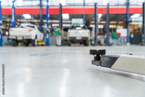 Select focus equipment electric lift for cars in the service put on the epoxy floor in new car factory service , Car repair service center blurred background for industry. © tong2530