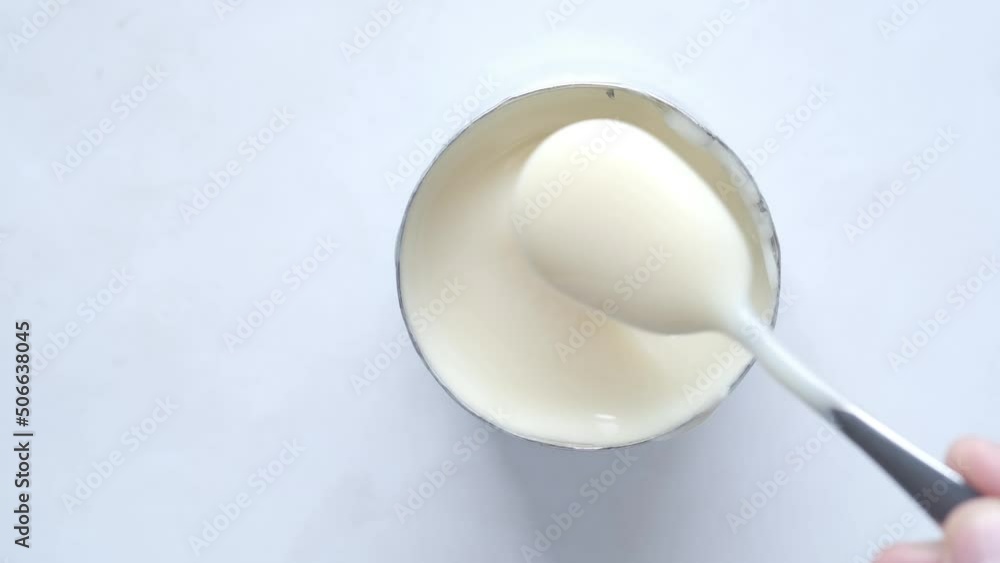 stirring condensed milk with a spoon in a bowl close up, stirring condensed milk with a spoon in a bowl close up,