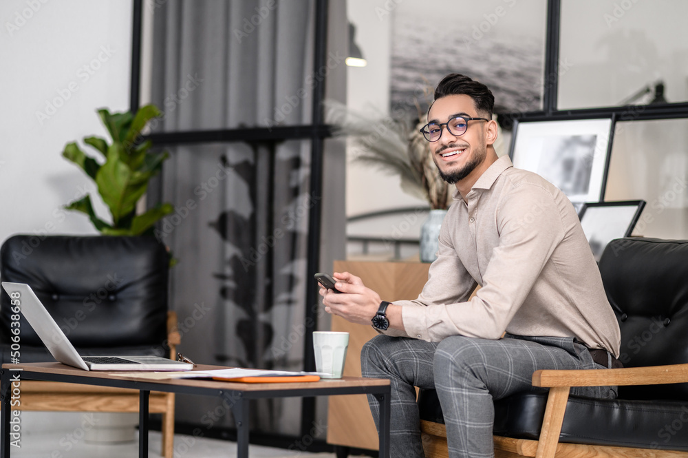 A young good-looking businessman sitting in the office A young good-looking businessman sitting in the office
