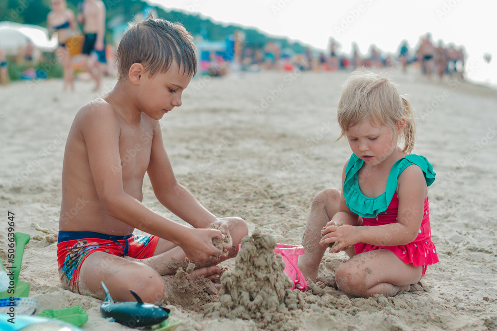 Brother and sister making sand castle on the beach Brother and sister making sand castle on the beach
