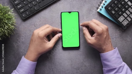 top view of man hand using smart phone on office desk  photo