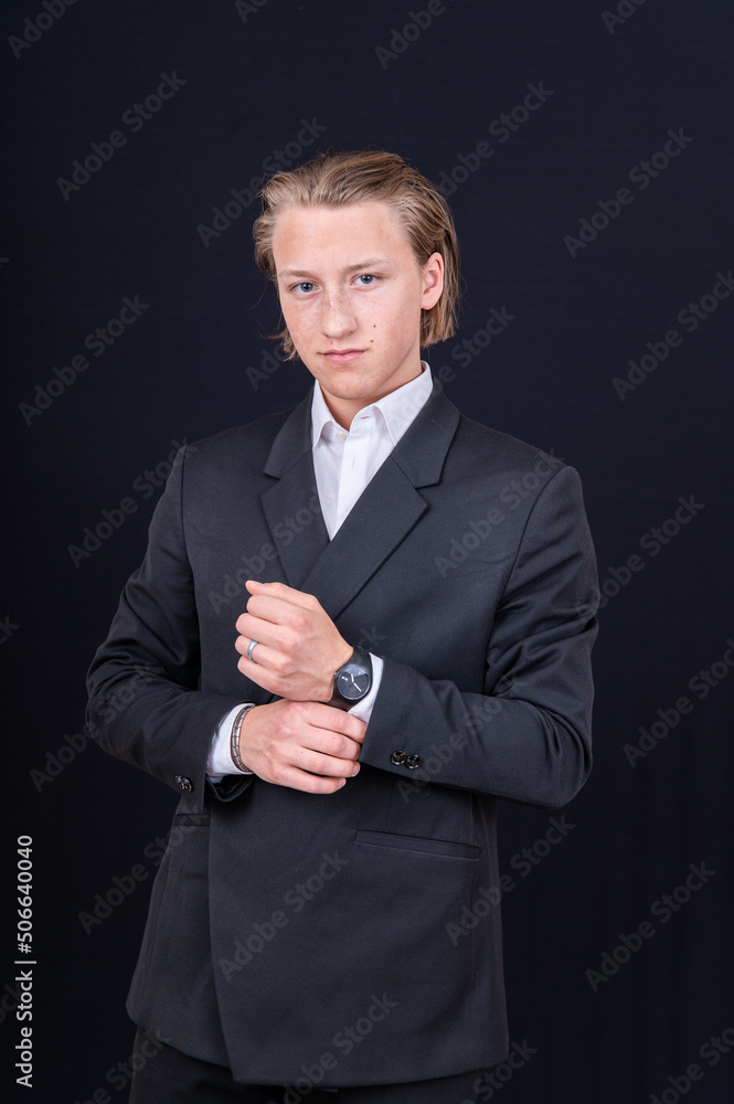 eleganter junger Mann im Anzug zeigt seine Uhr