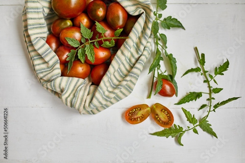 Market delivary of brown tomatoes in eco textile bag, Zero waste, Eco background, Assortment of tomatoes,  local farmers market, Fresh vegetables, harvest .Top view, copy space.