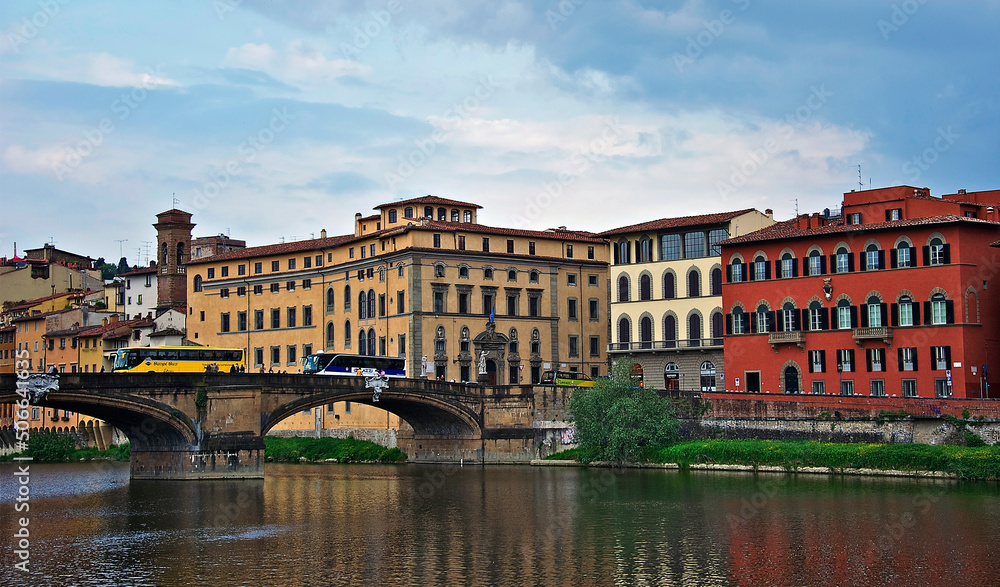 Colorful Quarter of Florence. The bridge over the river Arno leads to a colorful multi-colored quarter. Houses painted in different colors are reflected in the water. April 28, 2011. Italy, Florence, 