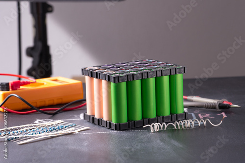 Lithium battery pack in black plastic holder on dark background.