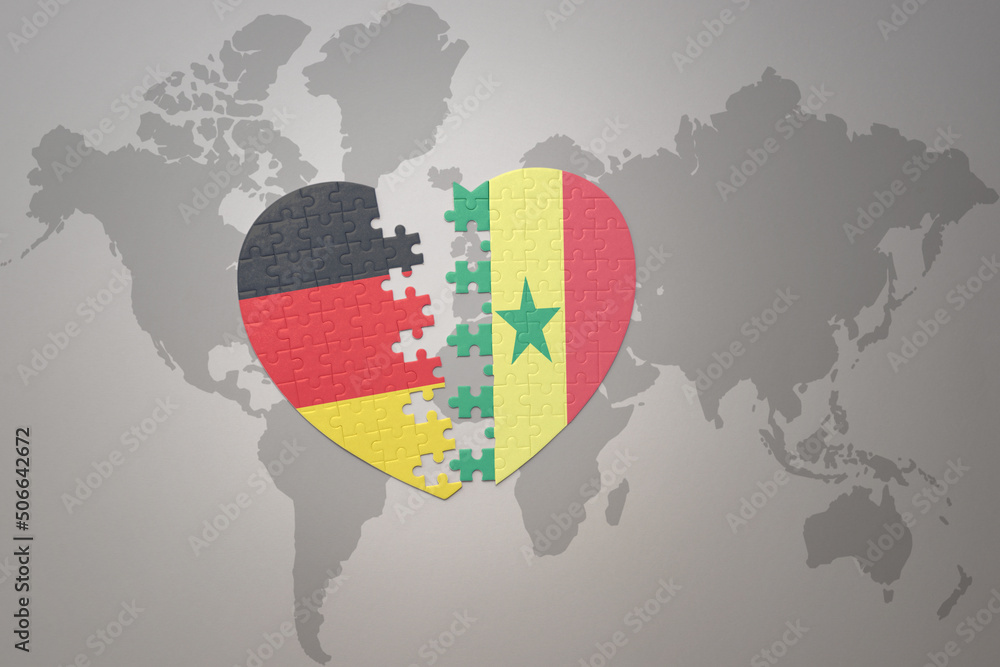 Fototapeta premium puzzle heart with the national flag of senegal and germany on a world map background. Concept.