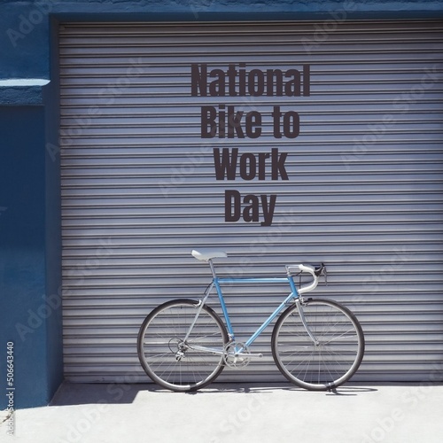 Digital composite image of national bike to work day text over bicycle against closed shutter