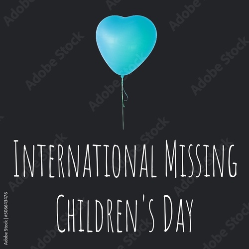 Heart shaped blue balloon with international missing children's day text on black background