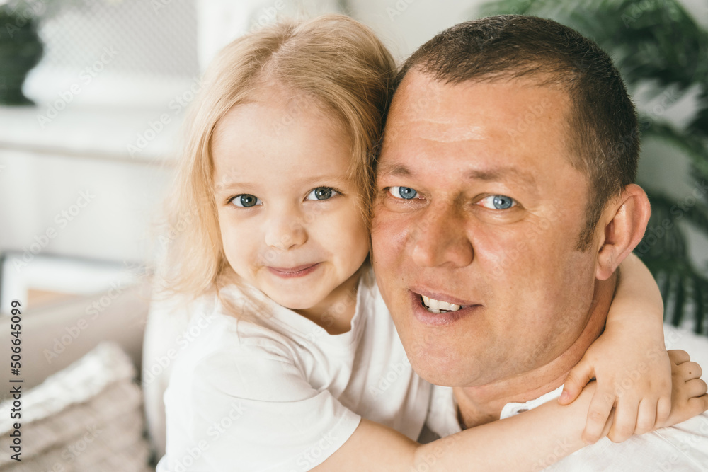 A little girl 4 years old gently hugs her dad. A little girl 4 years old gently hugs her dad.