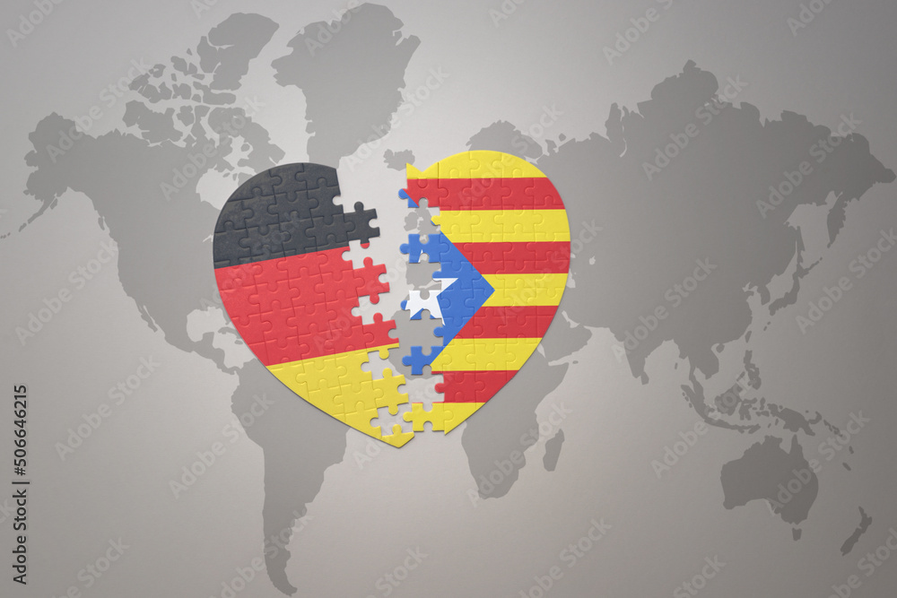 Obraz premium puzzle heart with the national flag of catalonia and germany on a world map background. Concept.