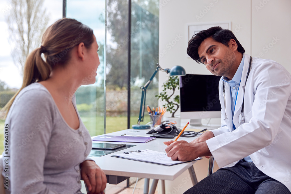 Male Doctor Or GP Wearing White Coat Examining Teenage Girl Listening To Chest With Stethoscope Male Doctor Or GP Wearing White Coat Examining Teenage Girl Listening To Chest With Stethoscope