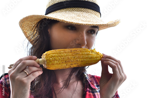 Young woman in hat eating grilled corn against white background