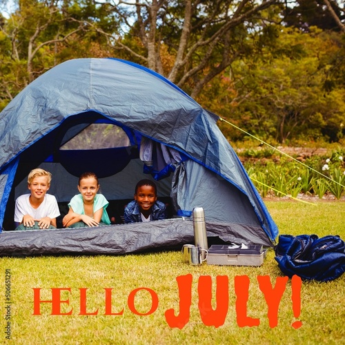 Composite image of hello july text and portrait of multiracial children relaxing in tent at forest