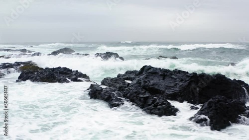 Cinematic drone shots of the Icelandic sea waves crashing over rocks. photo