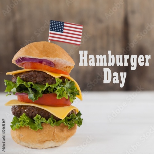 Composite image of hamburger with flag of america by text on table, copy space