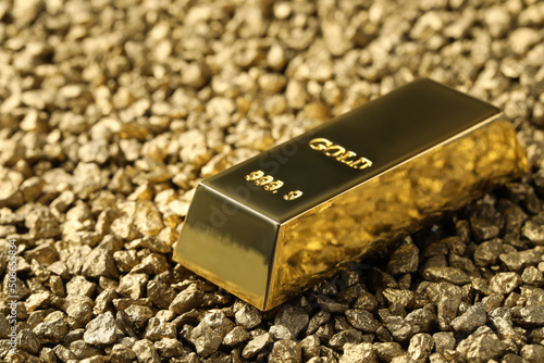 One gold ingot on nuggets, closeup view. Space for text photo