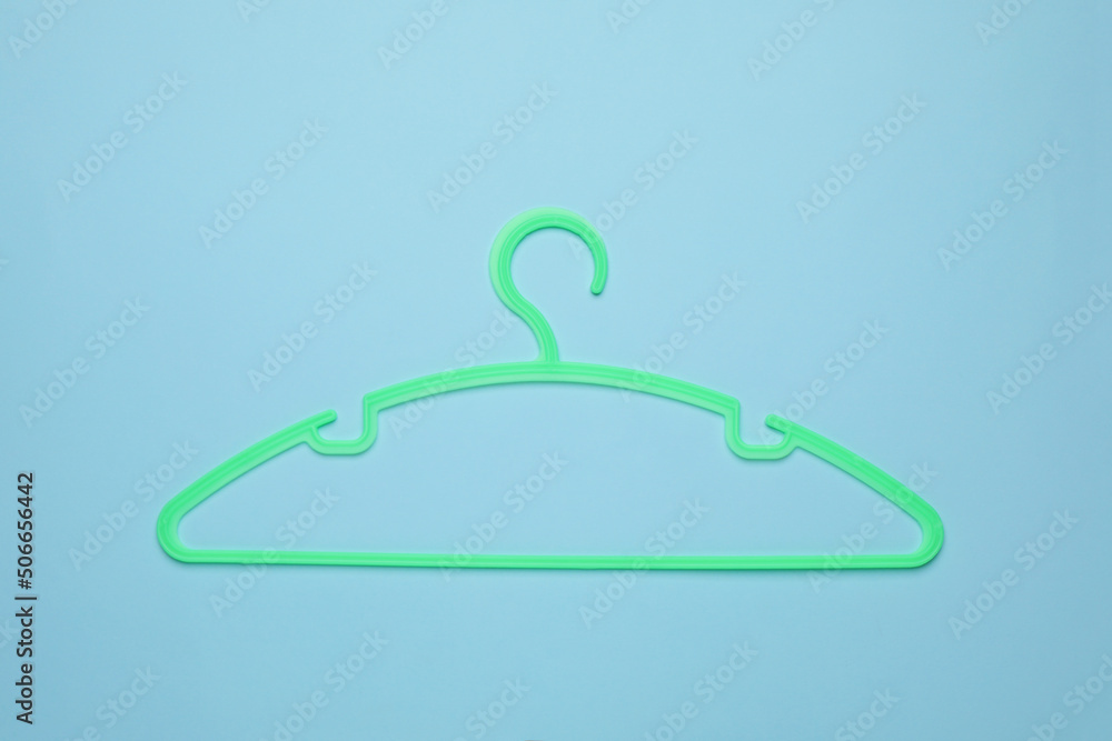 Empty clothes hanger on light blue background, top view Empty clothes hanger on light blue background, top view