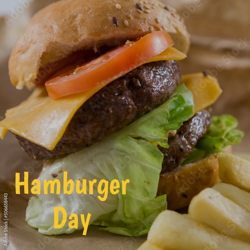 Close-up of hamburger day text with burger and french fries in plate, copy space