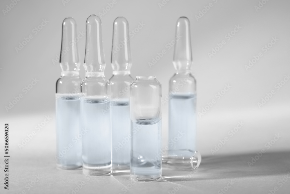 Pharmaceutical ampoules with medication on light grey background