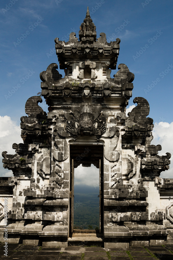 Majestic balinese culture Lempuyang temple in Bali - high heaven gate with towers carved of stone and door with view on valley, blue sky, vertical. Famous landmark of hindu, buddhism religion.