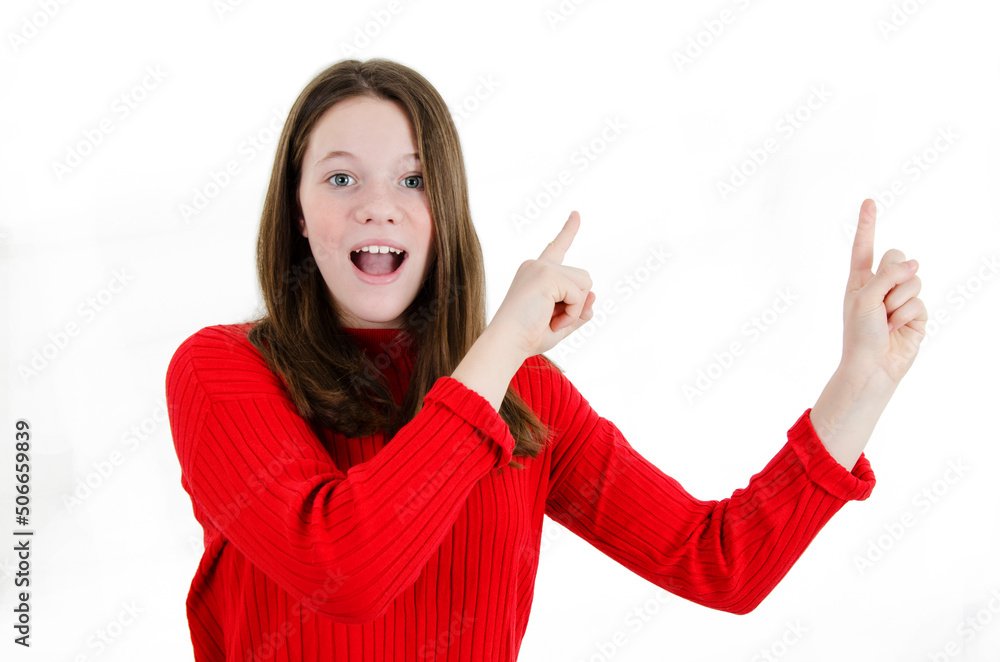 Excited teenage girl standing isolated on white background. Looking at camera screaming and showing copyspace pointing. Beautiful young girl pointing with both hands over the shoulder on copy space. Excited teenage girl standing isolated on white background. Looking at camera screaming and showing copyspace pointing. Beautiful young girl pointing with both hands over the shoulder on copy space.